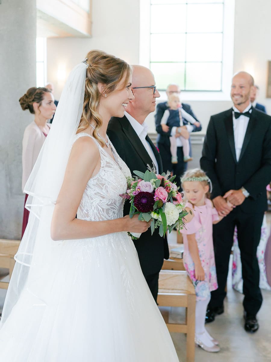 Braut wird von Vater in Kirche begleitet beim Einzug